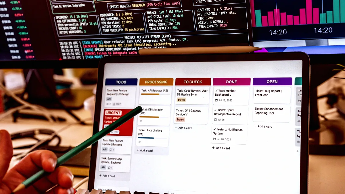 Poste de travail avec tableau kanban à l'écran d'un ordinateur portable et métriques sur un second écran