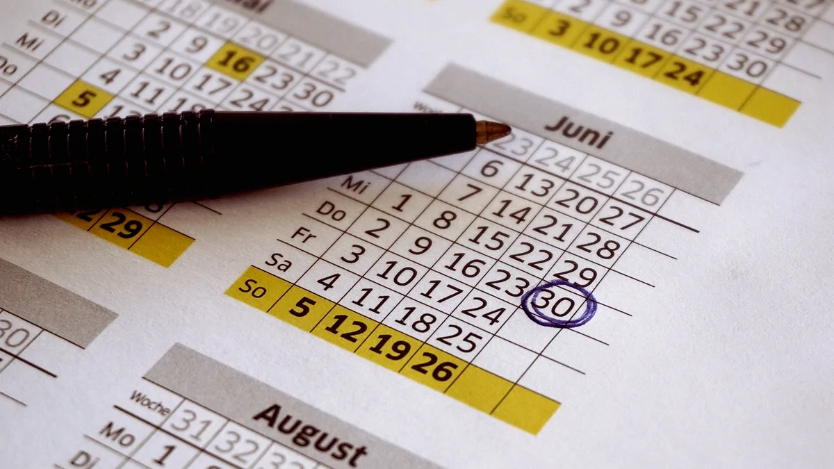 Calendrier papier avec une date entourée au stylo, stylo posé en travers