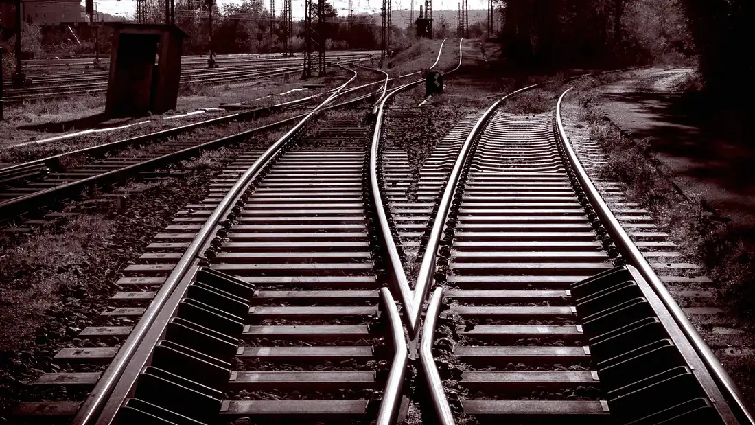 Aiguillage ferroviaire en noir et blanc, vu au ras des rails